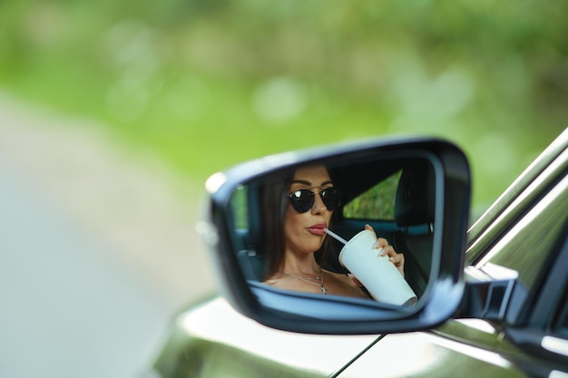 Reflet de femme dans le rétroviseur d'une voiture