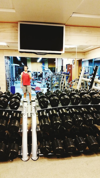 Photo le reflet d'un homme dans le miroir en prenant un selfie au gymnase