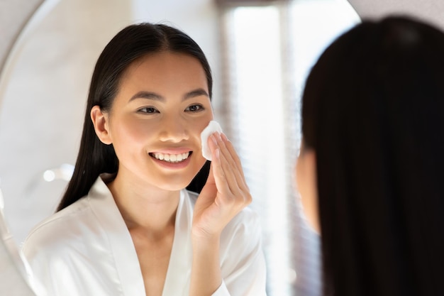 Reflet miroir d'une jolie femme asiatique à l'aide de tonner