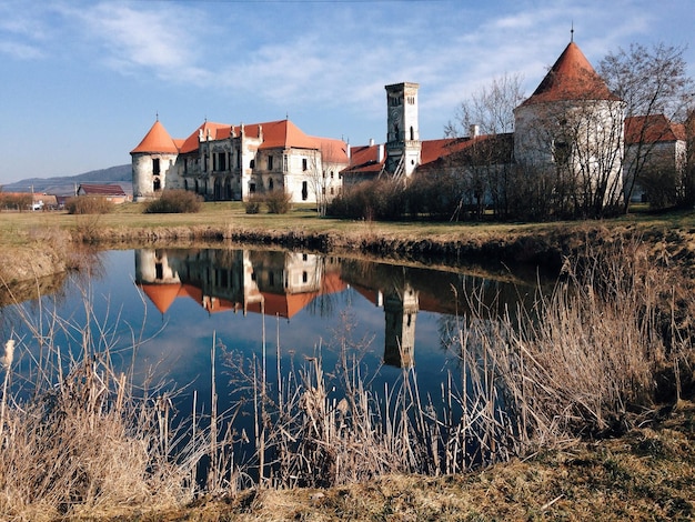 Réflexion des bâtiments dans le lac contre le ciel par une journée ensoleillée