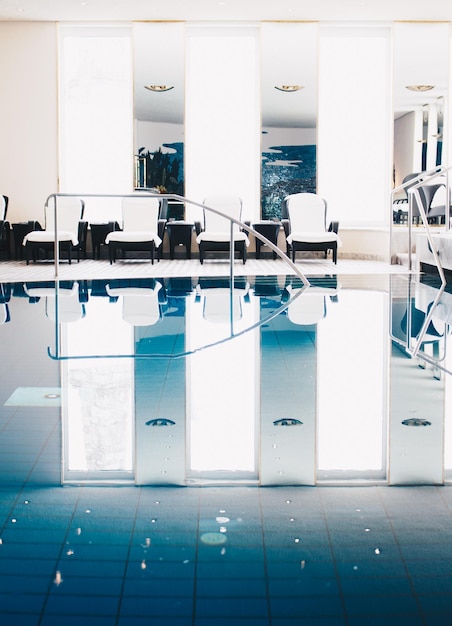 Photo réflexion de chaises dans la piscine