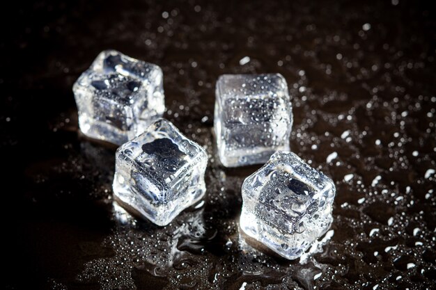 Réflexion de cubes de glace sur fond de tableau noir.