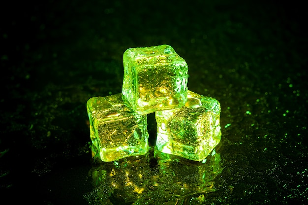 Réflexion de cubes de glace verte sur tableau noir.