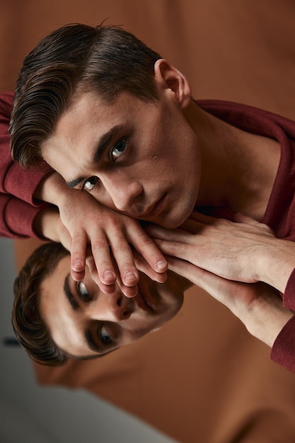 Réflexion d'hommes dans le miroir et modèle de chemise à fond brun Photo de haute qualité