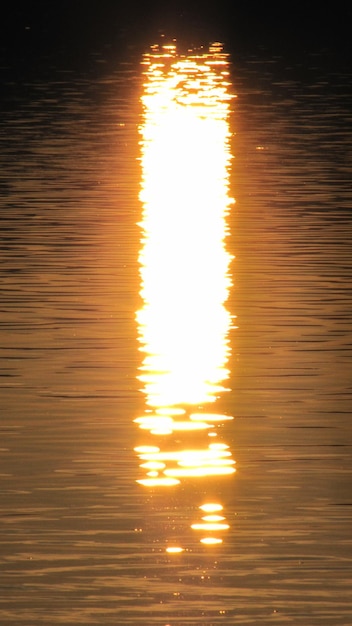 Photo réflexion de la lumière du soleil dans l'eau au coucher du soleil