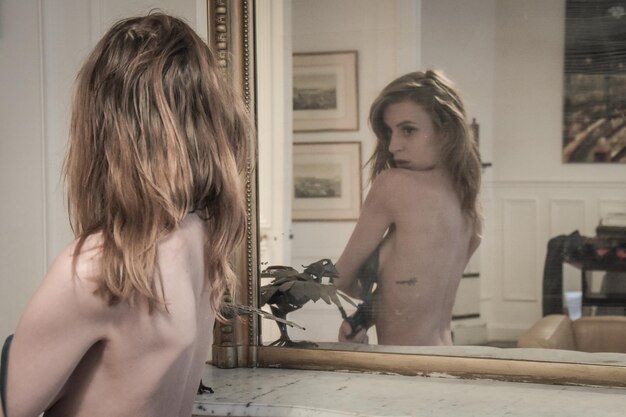 Photo réflexion d'un modèle féminin sensuel portant de la lingerie sur le miroir à la maison