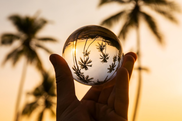 Réflexion de plage tropicale au coucher du soleil dans une boule de verre