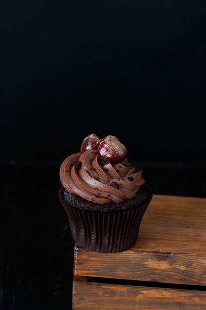 Un régal savoureux: un cupcake givré avec des cerises sur le dessus.