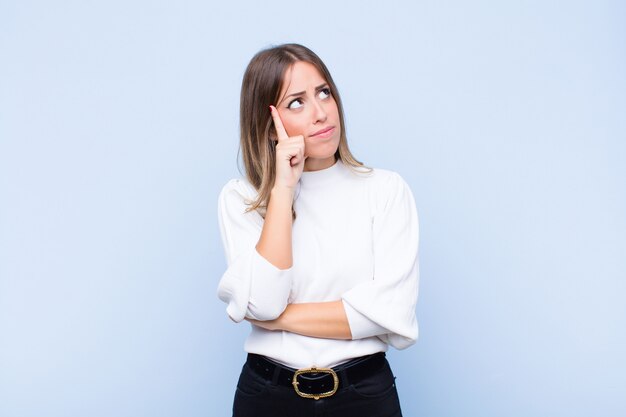 avec un regard concentré, se demandant avec une expression douteuse, levant les yeux et sur le côté