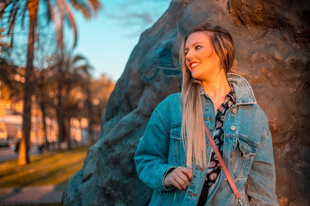 Regard d'une jeune blonde avec une veste regardant vers la gauche