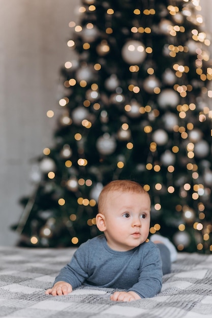 Regard surpris. La belle famille s'assied près de l'arbre de Noël avec des coffrets cadeaux le soir d'hiver