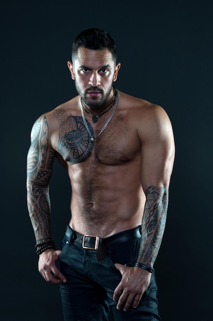 Regard tentant Homme barbu avec torse tatoué Torse nu macho sexy Modèle en forme avec tatouage sur la peau Sportif ou athlète avec barbe et cheveux Sport et fitness Masculinité Torse musclé