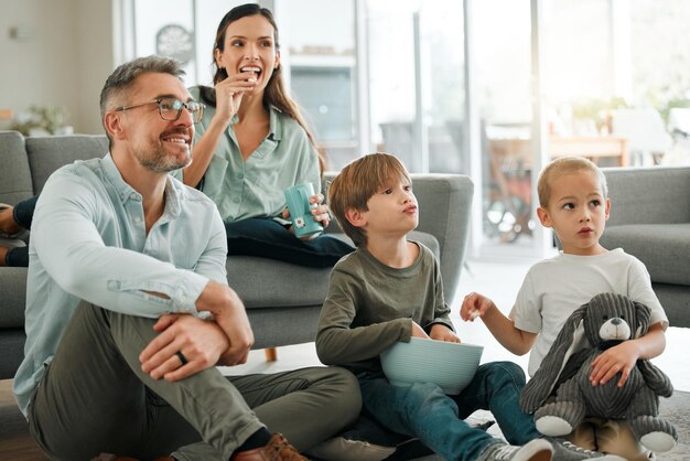 regardaient notre film préféré. Photo d'une jeune famille regardant la télévision ensemble à la maison.