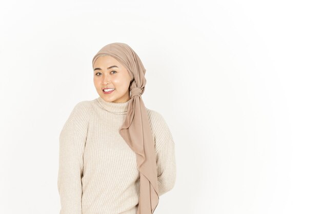 En regardant la caméra et le sourire de la belle femme asiatique portant le hijab isolé sur fond blanc