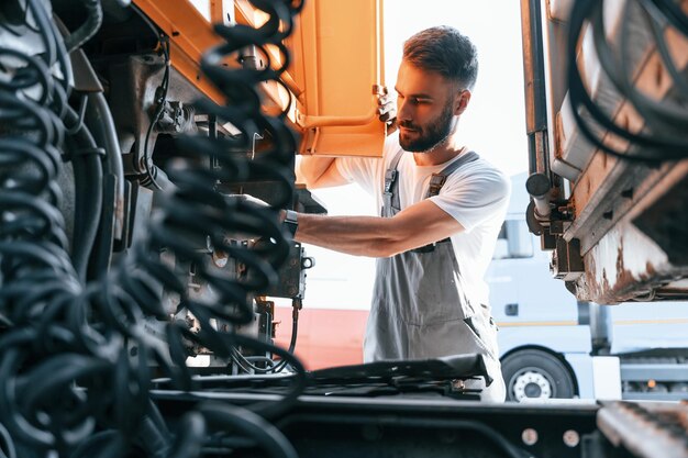 En regardant la connexion des fils Contrôle de sécurité Homme en unifrom faisant le service pour le gros véhicule de camion