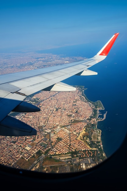 Regarder à travers la fenêtre des avions pendant le vol dans l'aile atterrit au-dessus d'istanbul par temps ensoleillé