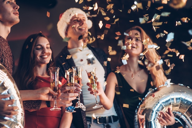 Regardez ces confettis. Photo de la compagnie d'amis ayant la fête avec de l'alcool