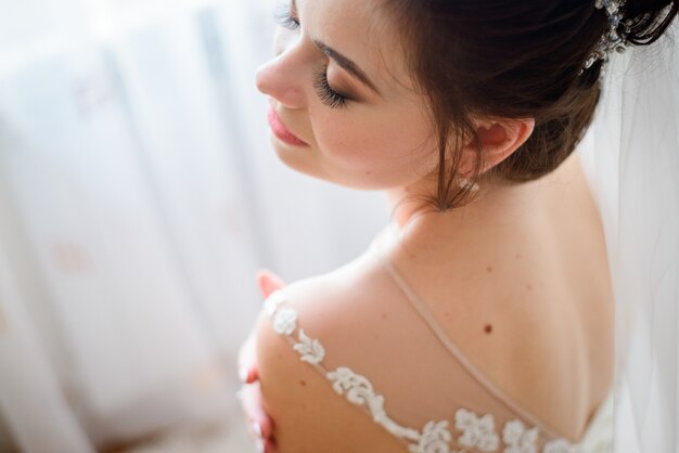 Regardez d&#39;en haut à la mariée tendre avec la peau de pêche debout avec les yeux fermés