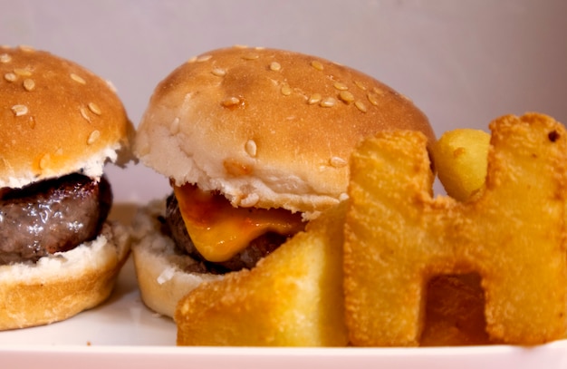 Regardez de près les mini hamburgers accompagnés de frites en forme de lettres