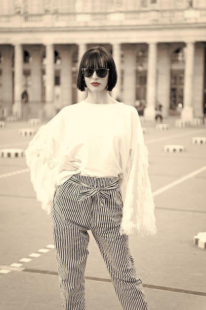 Regardez et style rétro femme avec des cheveux bruns courts élégants et des lèvres rouges sur le fond de la rue beauté et mode vintage noir et blanc