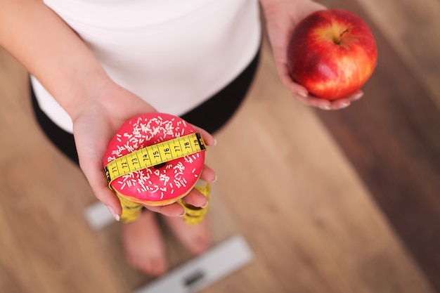 Photo régime alimentaire, femme, poids corporel mesuré, balance, tenue, beignet, pomme