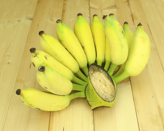 Régime de bananes sur fond de table en bois.