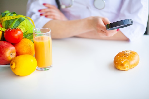 Régime. Le Docteur Nutritionniste Tient Une Galette Dans Son Bureau. Concept De Nourriture Naturelle Et De Mode De Vie Sain. Fitness Et Concept De Régime Alimentaire Sain. Alimentation équilibrée Avec Des Légumes.