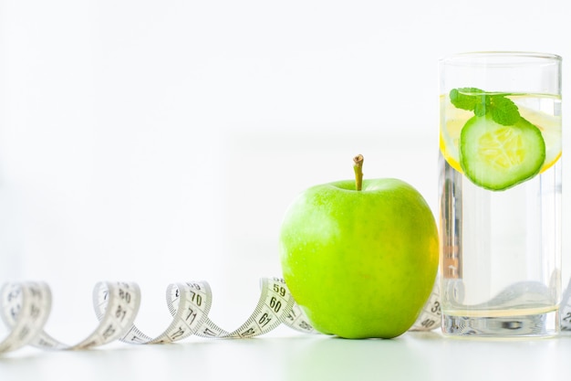 Régime. Fitness et concept de régime alimentaire des aliments sains. Régime équilibré avec des fruits. Fruits frais et eau de verre, ruban à mesurer