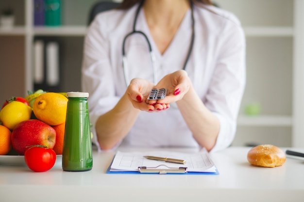 Régime. Nutritionniste femme tenant des ampoules de pilules