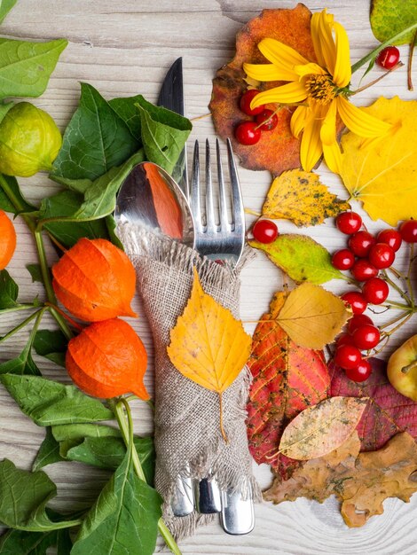 Réglage de la coutellerie d'automne de thanksgiving et arrangement de feuilles d'automne colorées baies rouges