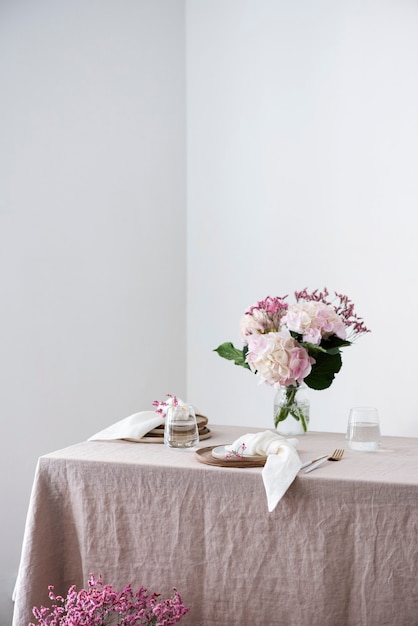 Réglage de la table avec des assiettes en céramique faites à la main sur une nappe en lin et des fleurs. Notion de fête