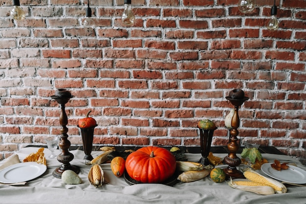 Réglage de la table d'automne pour le jour de Thanksgiving avec des citrouilles et des bougies