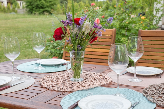 Réglage de la table de banquet fine avec bouquet dans le jardin. Notion de fête