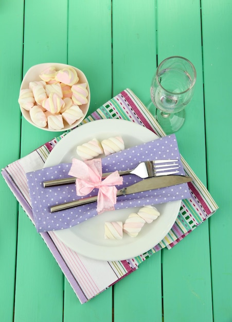 Réglage de la table dans des tons violets et blancs sur fond de bois de couleur