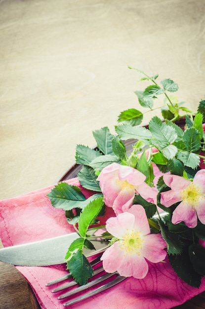 Réglage de la table de fête avec des fleurs roses.