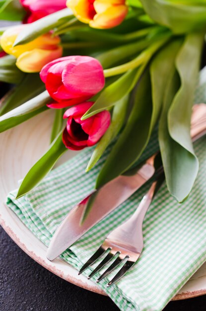 Réglage de la table de fête avec des tulipes pour l'anniversaire, la fête des mères ou pour d'autres vacances.