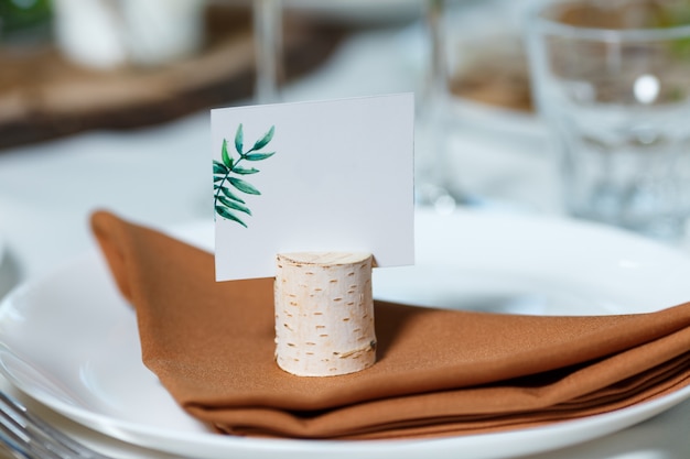 Réglage de la table de mariage avec carte d'hôte vierge sur un plat