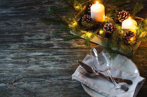 Réglage de la table de Noël avec des bougies et des branches de sapin