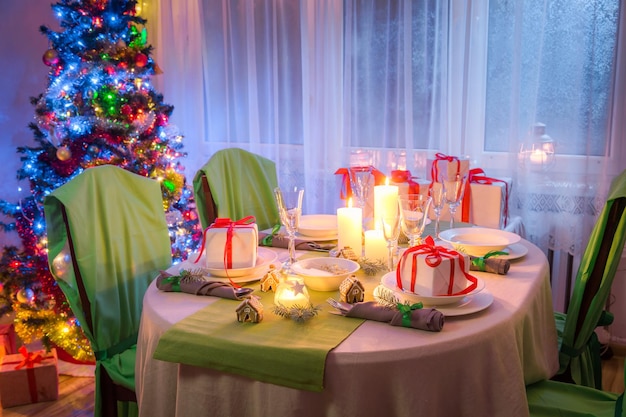 Réglage de la table de Noël avec des bougies et du pain d'épice en soirée