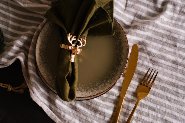 Réglage de la table de Noël avec un élégant rond de serviette en or sur une assiette