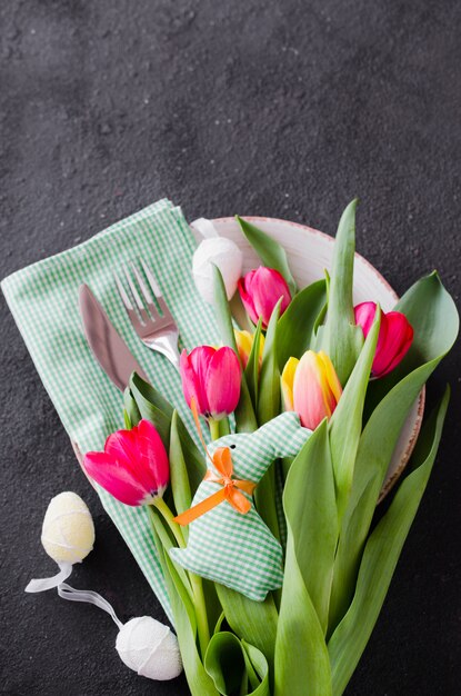 Réglage de la table de Pâques avec bouquet de tulipes et couverts.