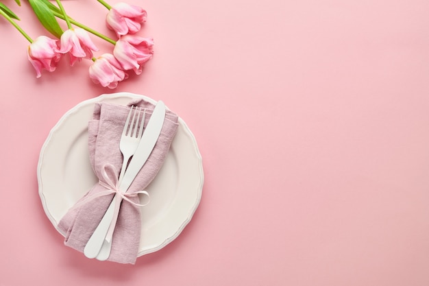 Réglage de la table de Pâques avec décor floral sur table rose