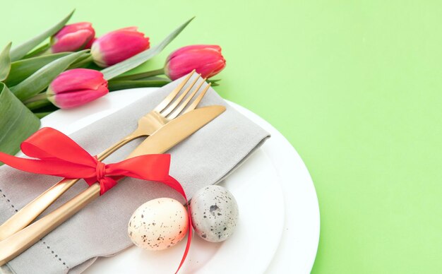 Réglage de la table de Pâques fleurs de printemps jaune serviette et couverts dorés sur des assiettes blanches