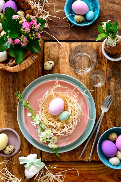 Réglage de la table de Pâques, idée de décoration de table de vacances, composition à plat avec couverts, œufs de Pâques et fleurs fraîches