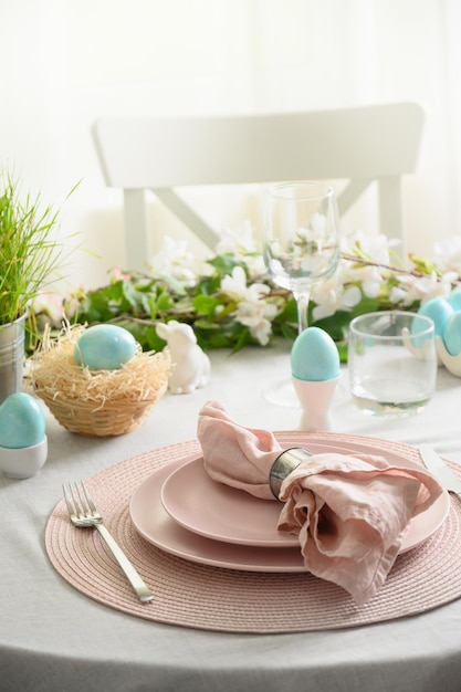 Réglage de la table de Pâques avec des oeufs colorés bleus décorations festives fleurs fraîches