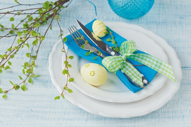 Réglage de la table de Pâques avec des œufs peints et des couverts