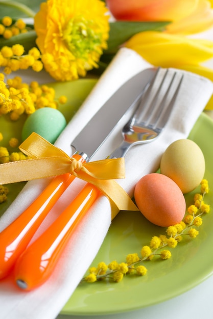Photo réglage de la table de pâques avec des tulipes jaunes et des fleurs de mimosa se bouchent