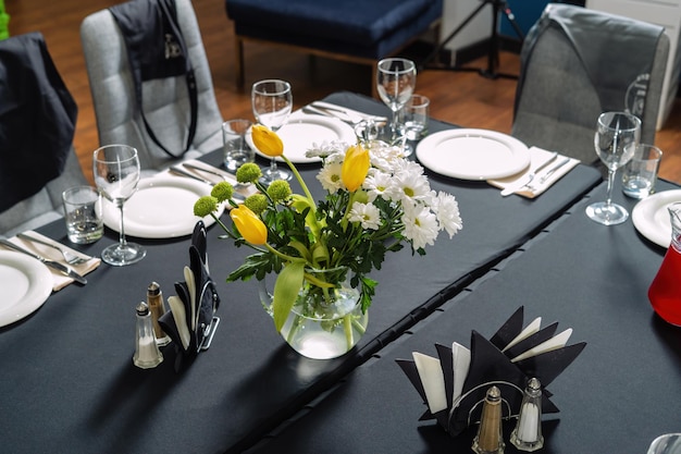 Réglage de la table pour un mariage ou un dîner nappe noire assiettes blanches élégante et belle