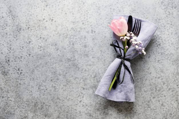 Réglage de table printemps élégance avec tulipe rose sur gris. Réglage de la table de mariage. Vue de dessus.