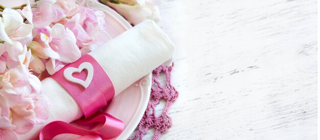 Photo réglage de la table romantique avec des fleurs de freesia et un ruban rose bouchent avec copie espace